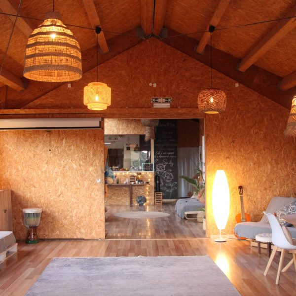 Espaço comum com decoração rústica e natural, móveis simples e luzes suaves, ideal para convívio, relaxamento e atividades partilhadas em grupo.